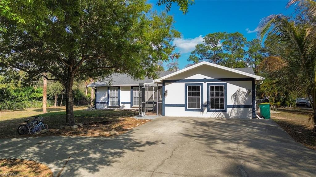 View of front of property featuring driveway and a front lawn