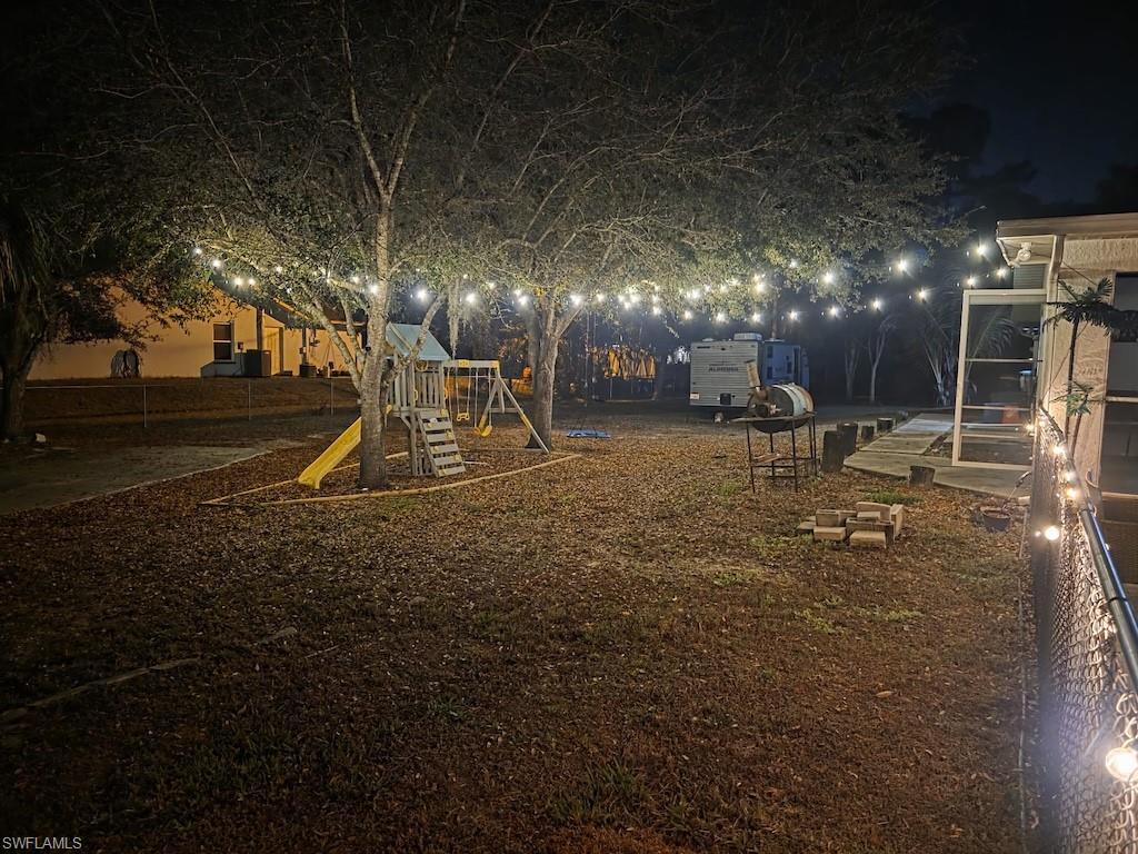 Yard at night featuring a playground