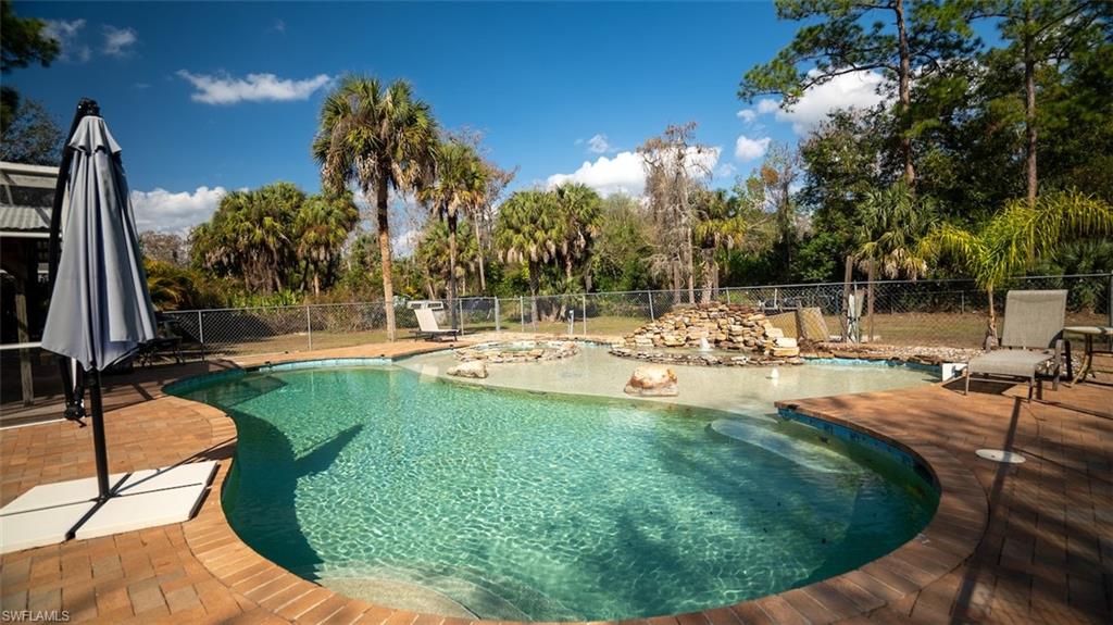 View of swimming pool featuring patio surround and a fenced backyard