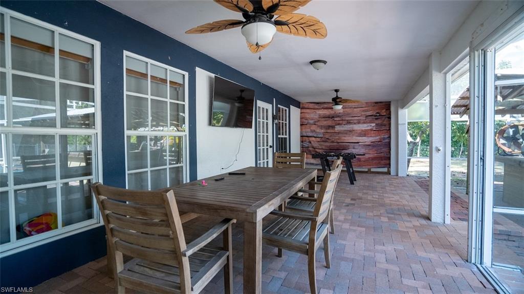 Sunroom / solarium featuring a ceiling fan, outdoor dining space, french doors, and a patio