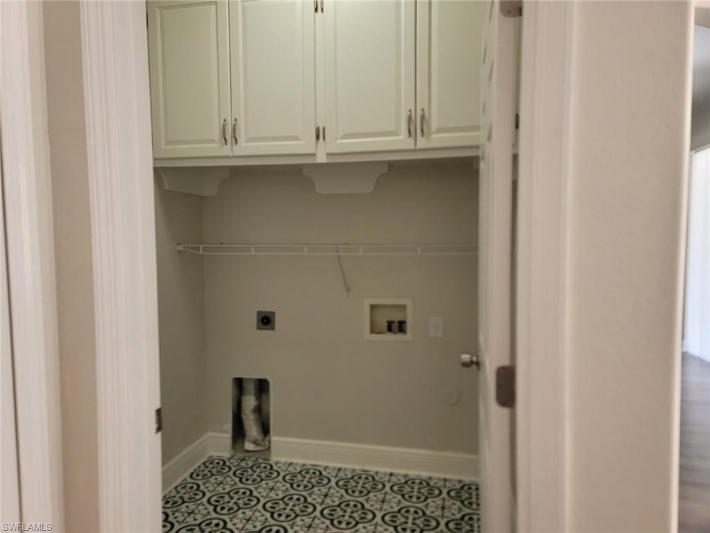 Laundry area with hookup for a washing machine, electric dryer hookup, and cabinet space