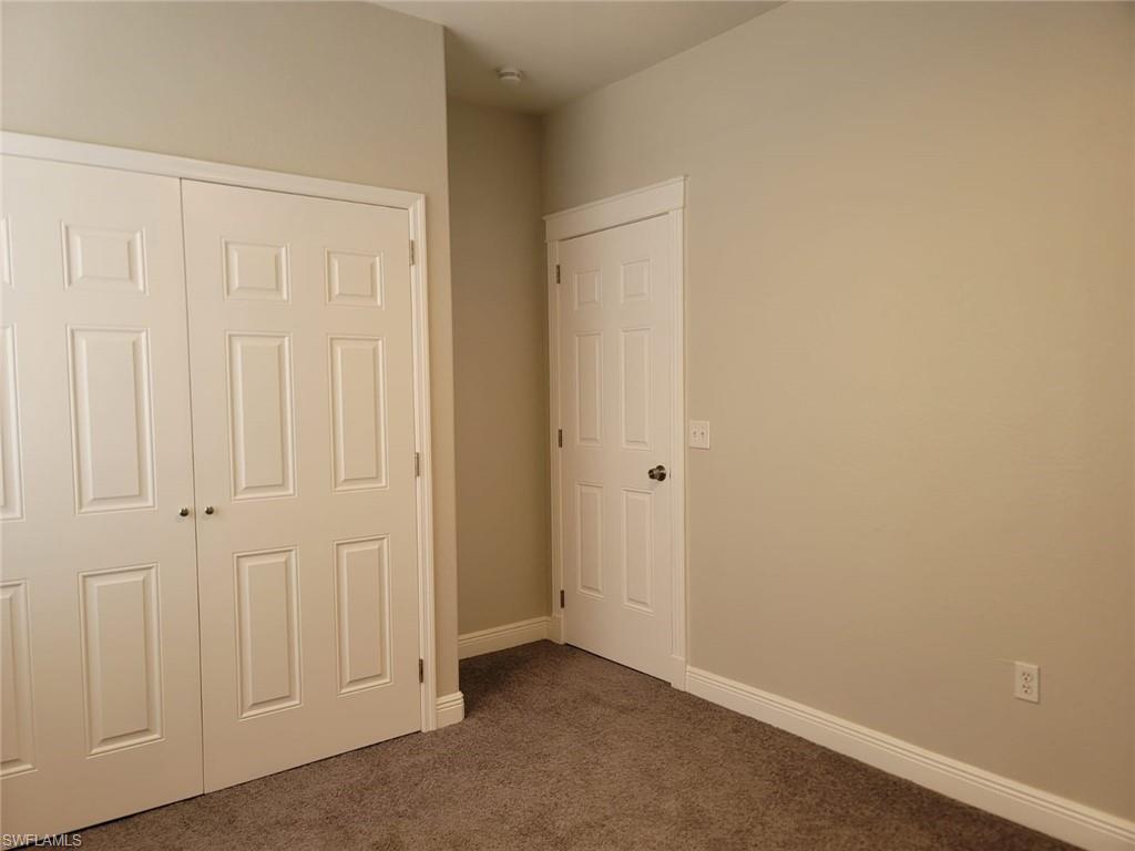 Unfurnished bedroom with a closet and dark colored carpet