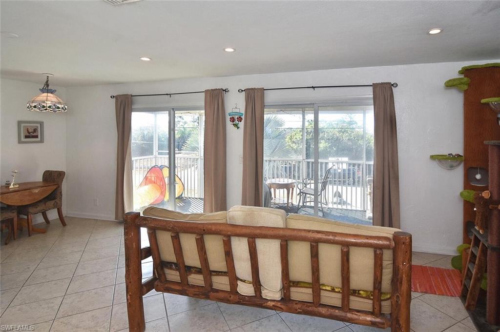 Dining space with light tile patterned floors and recessed lighting
