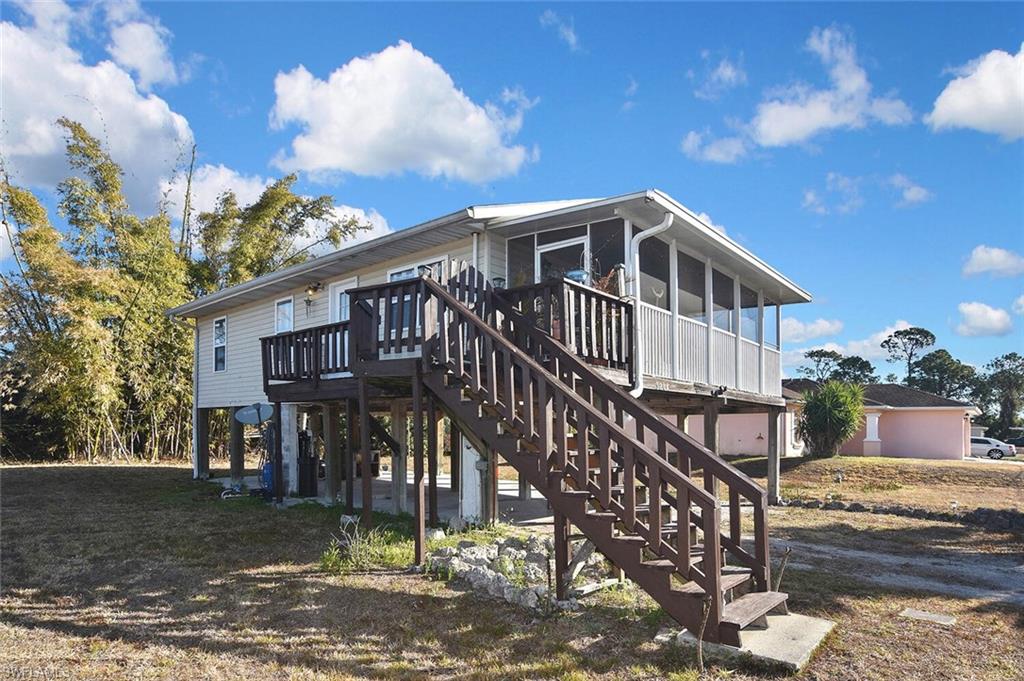 Rear view of property featuring stairway and a deck