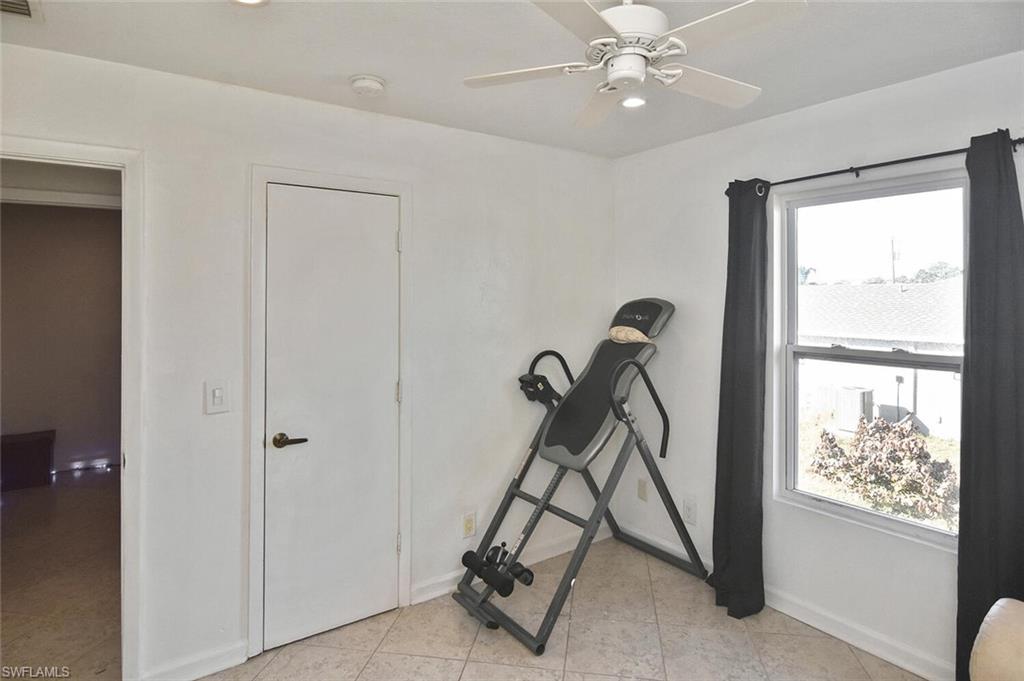 Workout area featuring ceiling fan, recessed lighting, and light tile patterned flooring