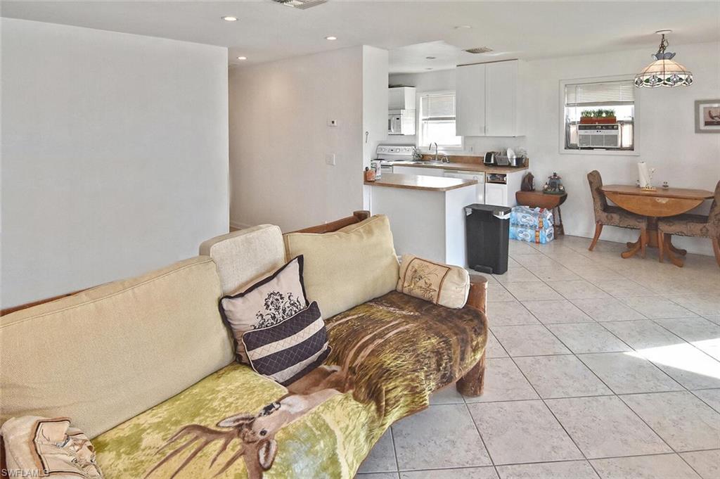 Living area with light tile patterned floors, recessed lighting, and cooling unit