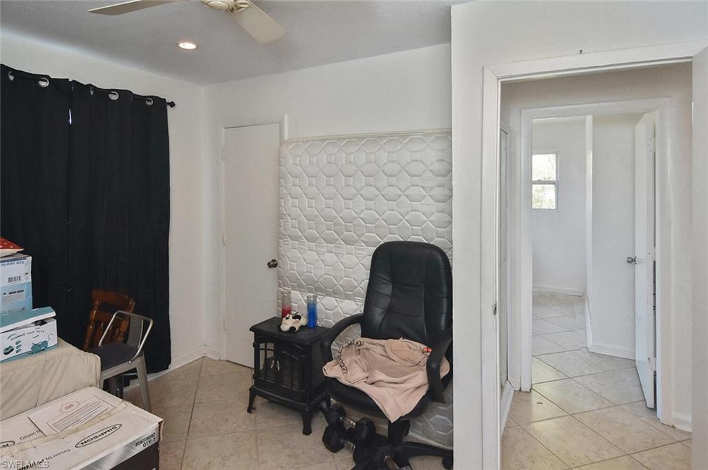 Office area featuring light tile patterned floors and ceiling fan