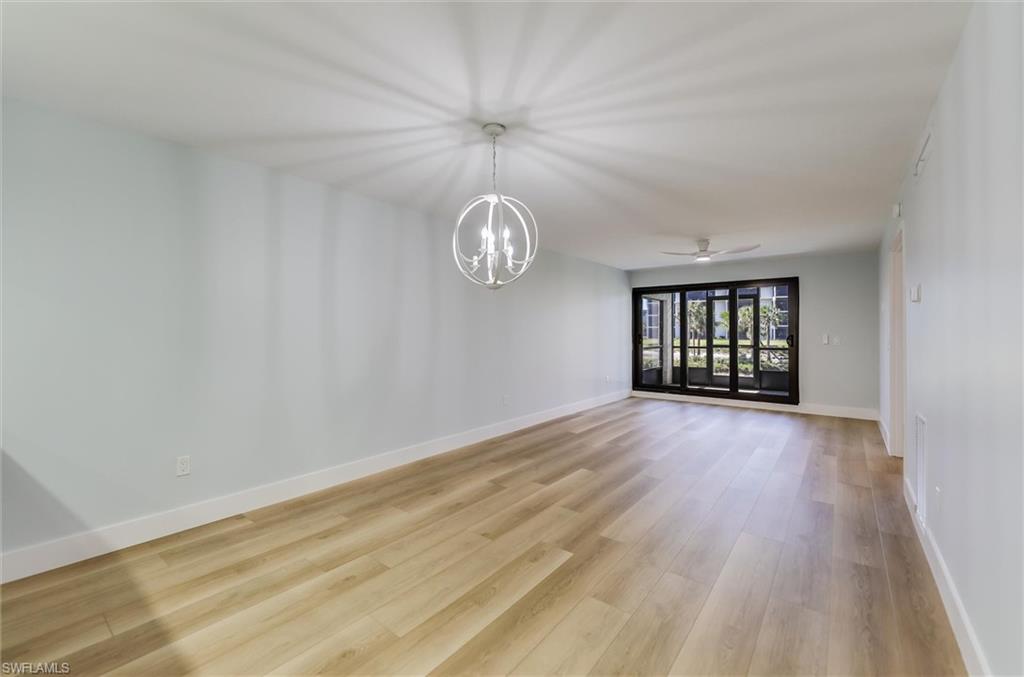 Empty room featuring hanging lights, a ceiling fan, and light wood finished floors