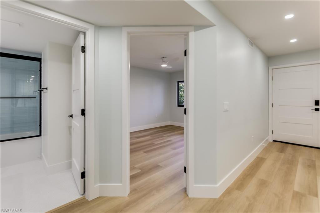 Corridor with light wood-style flooring and recessed lighting