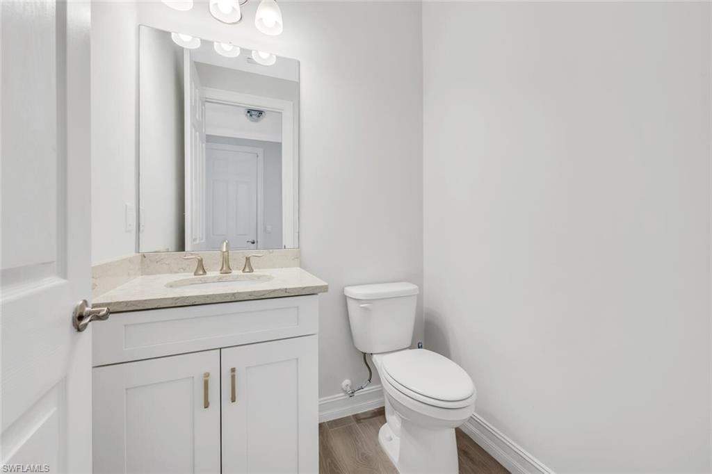 Half bath featuring vanity and wood finished floors