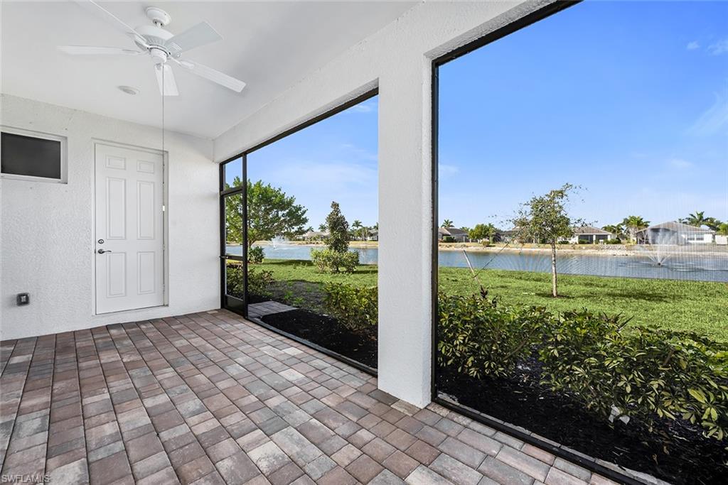Unfurnished sunroom with ceiling fan and a water view