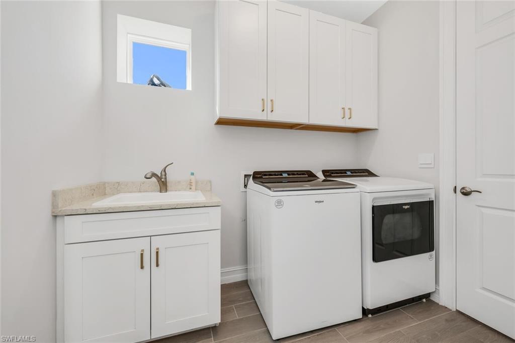 Laundry area with cabinet space, washer and dryer, and wood tiled floors