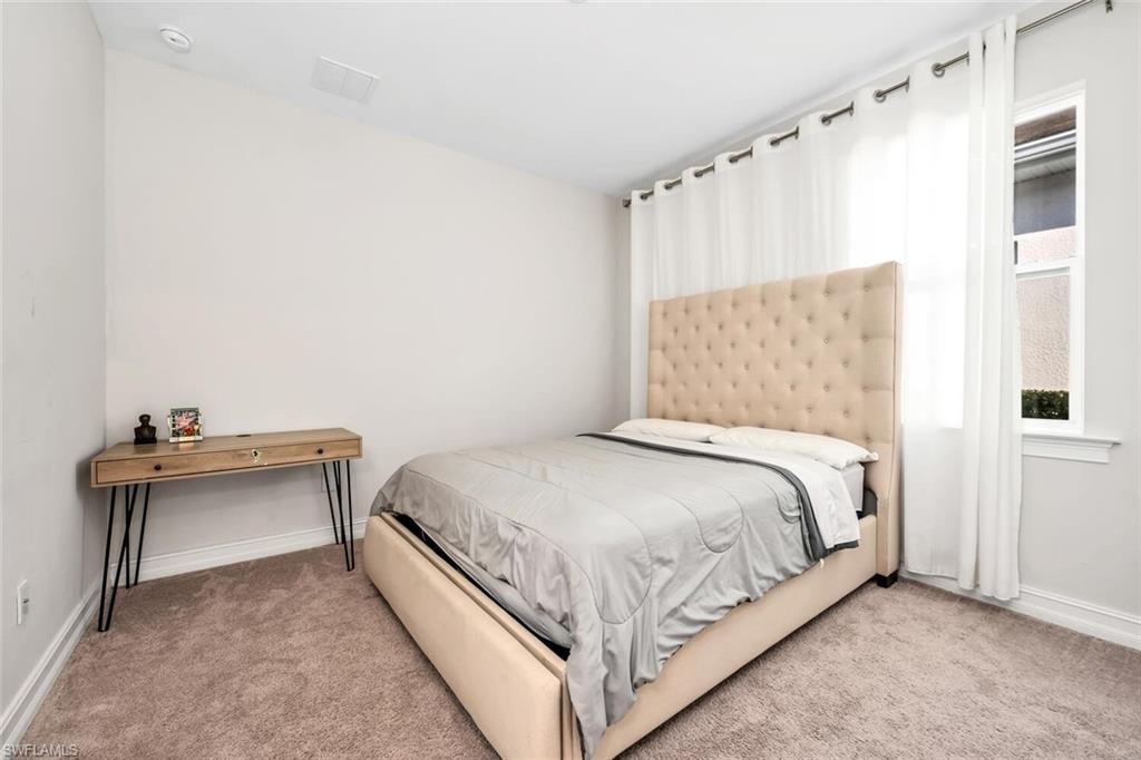 Bedroom with baseboards and light carpet