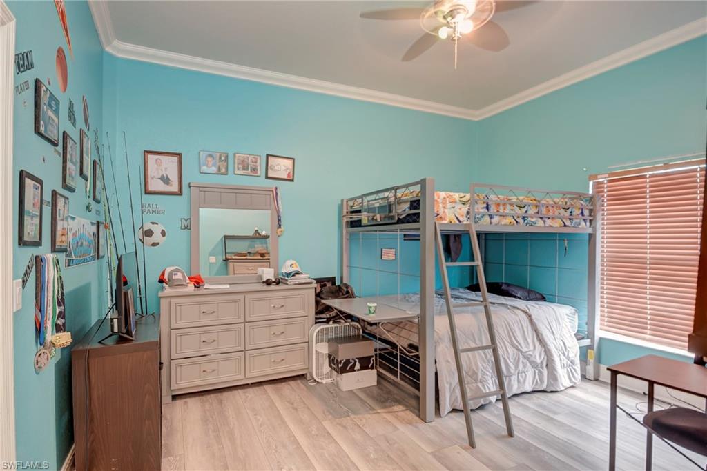 Bedroom featuring ornamental molding, light wood finished floors, and ceiling fan