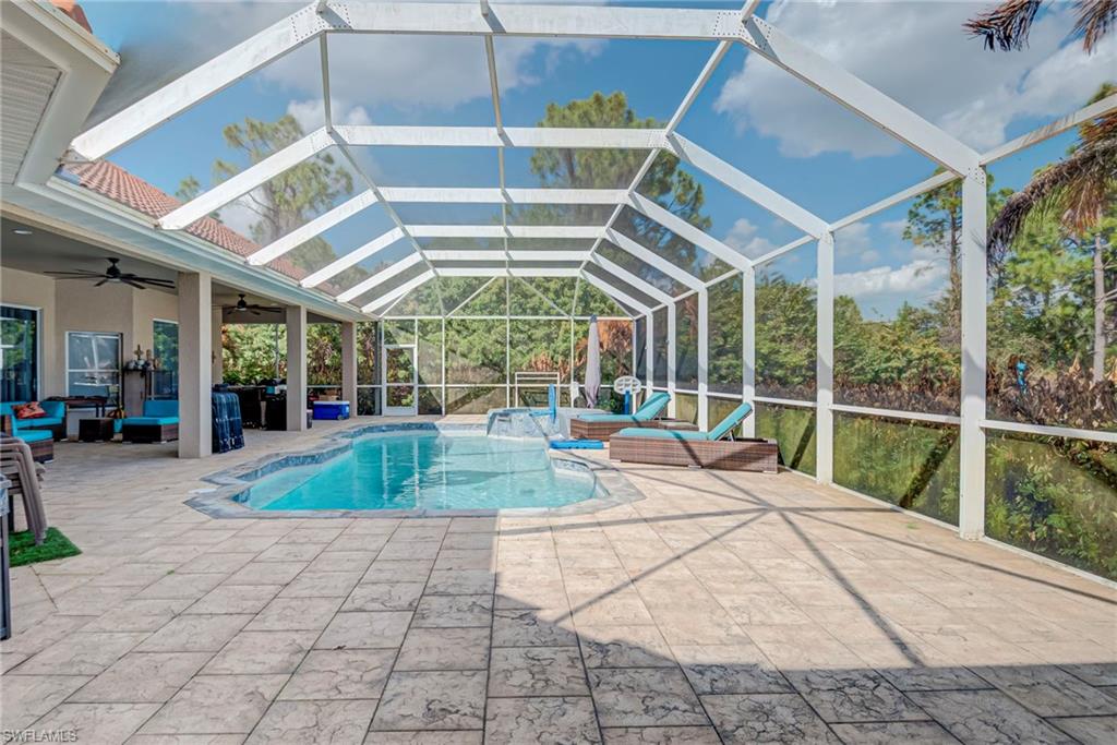 Swimming pool with a sunroom, outdoor lounge area, a lanai, and a patio