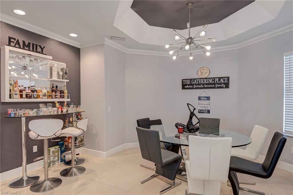 Dining area with crown molding, hanging lights, and tile patterned floors