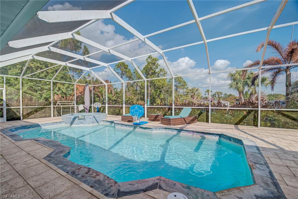 Integrated pool / spa featuring a lanai, a sunroom, and a patio