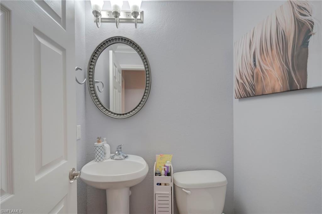Half bath with toilet and a textured wall