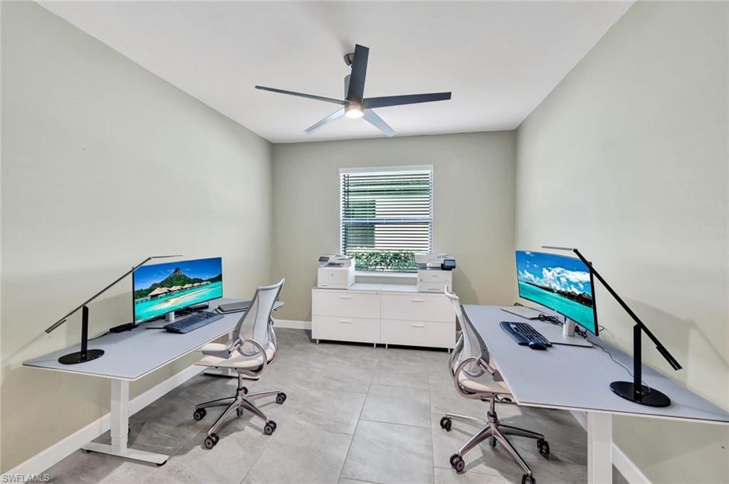 Home office with a ceiling fan and baseboards