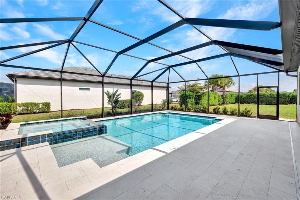 Integrated pool / hot tub with a sunroom, a lanai, and a patio