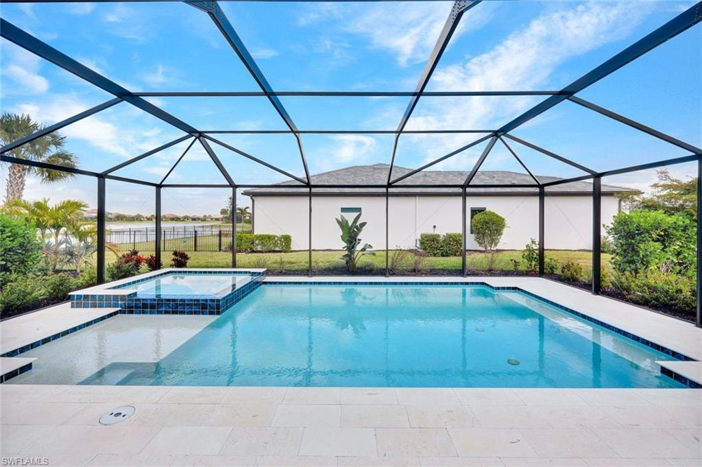 Combined pool / hot tub with a sunroom, a patio, a lanai, and a yard