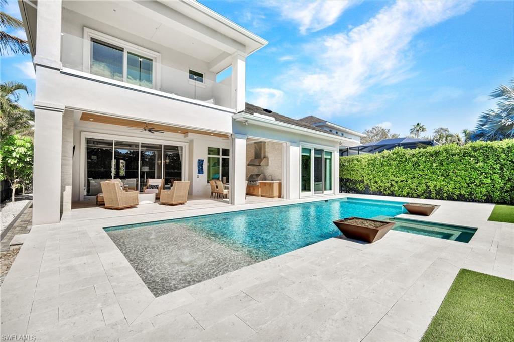 Back of property with a patio, a balcony, ceiling fan, stucco siding, and an outdoor living space