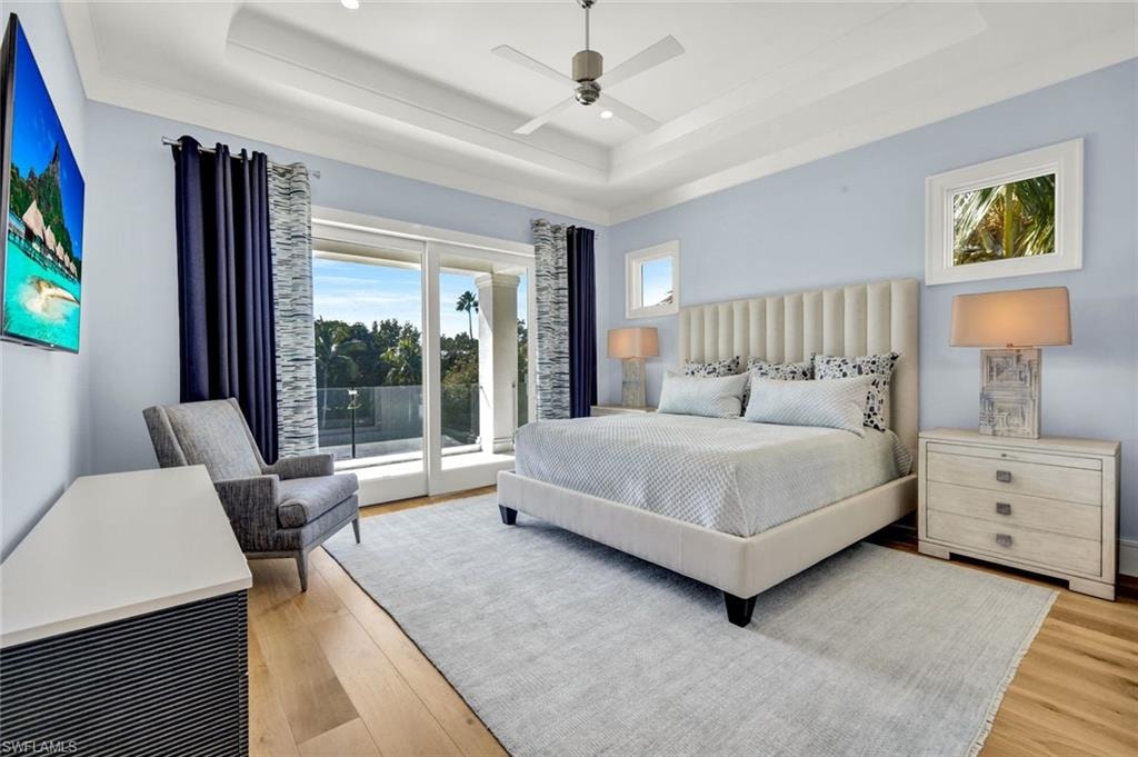Bedroom with access to outside, light wood finished floors, and a ceiling fan