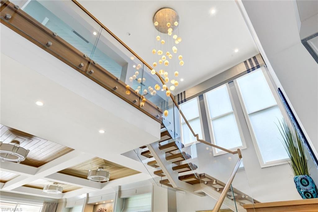 Stairs featuring coffered ceiling and recessed lighting