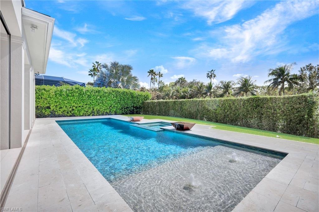 Combined pool / hot tub with a patio and a fenced backyard