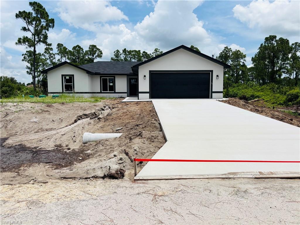 Contemporary single-story residence featuring a dark asphalt shingle roof and a smooth stucco exterior