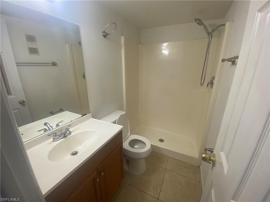 Bathroom with vanity, a stall shower, and light tile patterned flooring