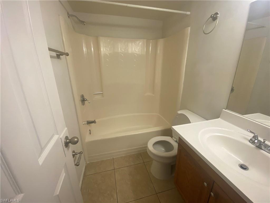 Bathroom with vanity, light tile patterned flooring, and shower / tub combination