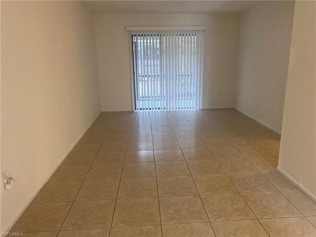 Unfurnished room featuring light tile patterned floors and baseboards