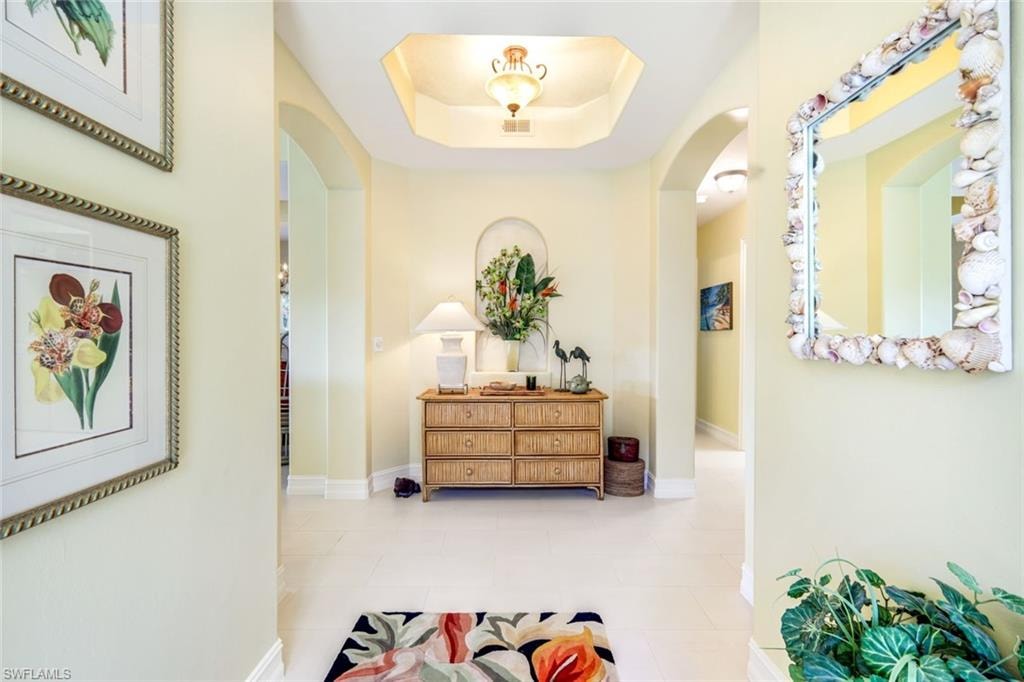 Corridor with a tray ceiling and arched walkways