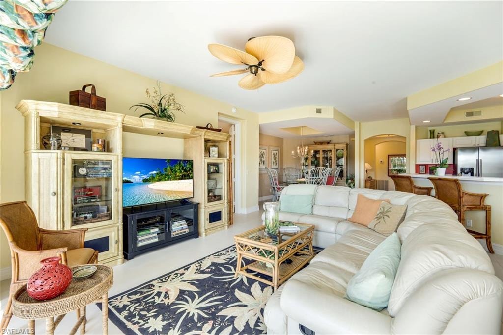 Living room featuring recessed lighting, ceiling fan, and arched walkways