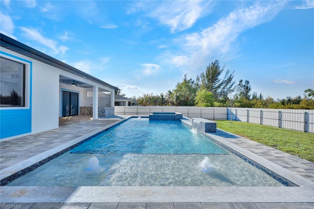 Integrated pool / spa with a patio and a fenced backyard