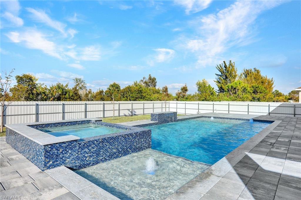 Relaxing pool / spa featuring a patio area and a fenced backyard