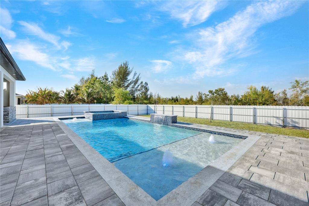 Combined pool / hot tub featuring a fenced backyard and a patio