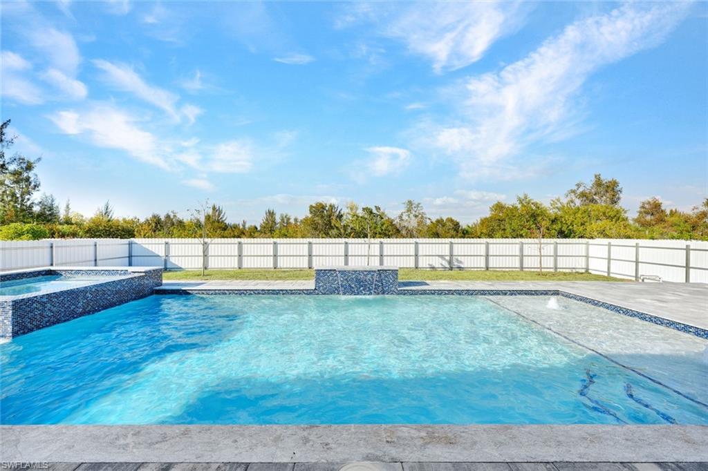 Relaxing pool / spa with a fenced backyard and a patio area