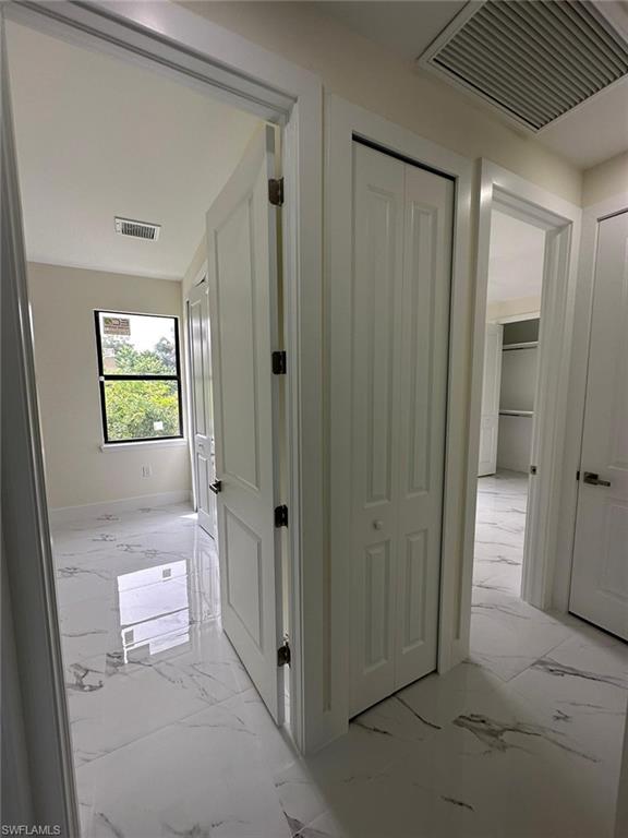 Hall featuring light marble finish flooring