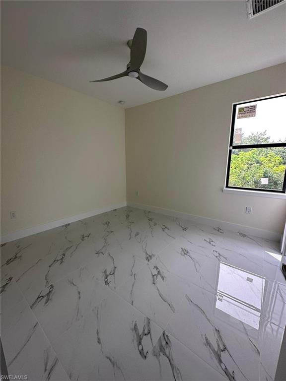 Empty room with ceiling fan and light marble finish flooring