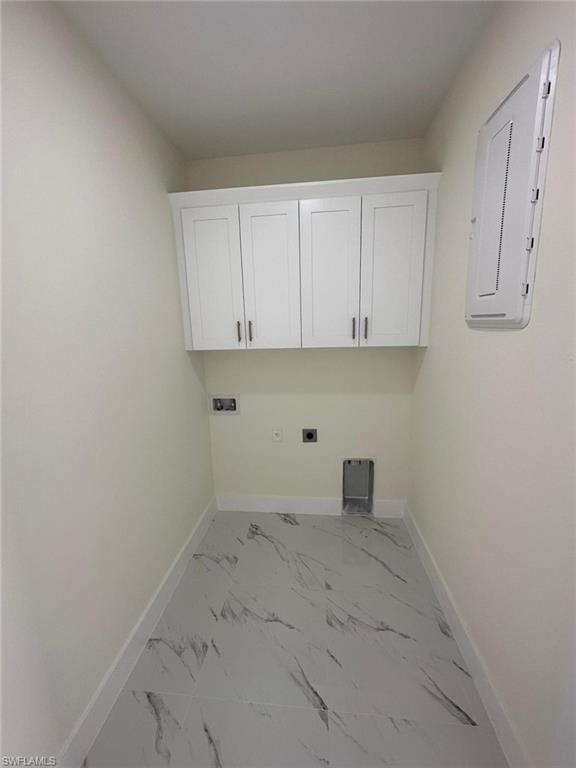 Laundry area featuring electric dryer hookup, light marble finish floors, cabinet space, electric panel, and hookup for a washing machine