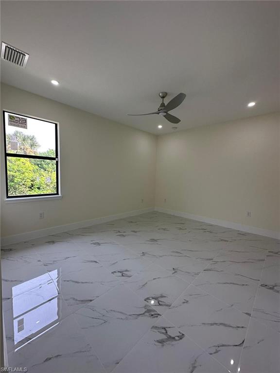 Unfurnished room featuring ceiling fan, recessed lighting, and light marble finish floors