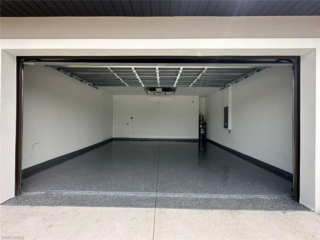 Garage featuring baseboards and electric panel