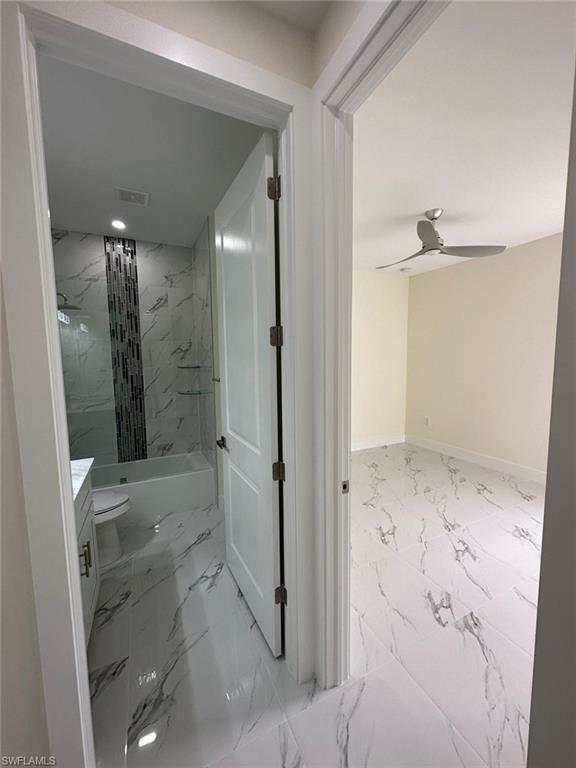 Bathroom with vanity, light marble finish floors, and a ceiling fan