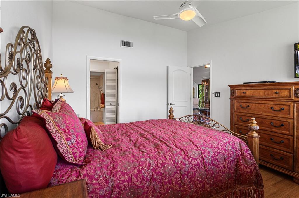 Primary bedroom continues vaulted ceiling, and has wood floors and a lake view!
