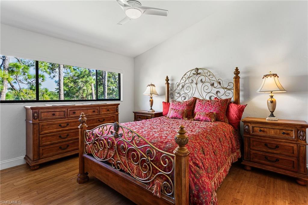 Primary bedroom continues vaulted ceiling, and has wood floors and a lake view!