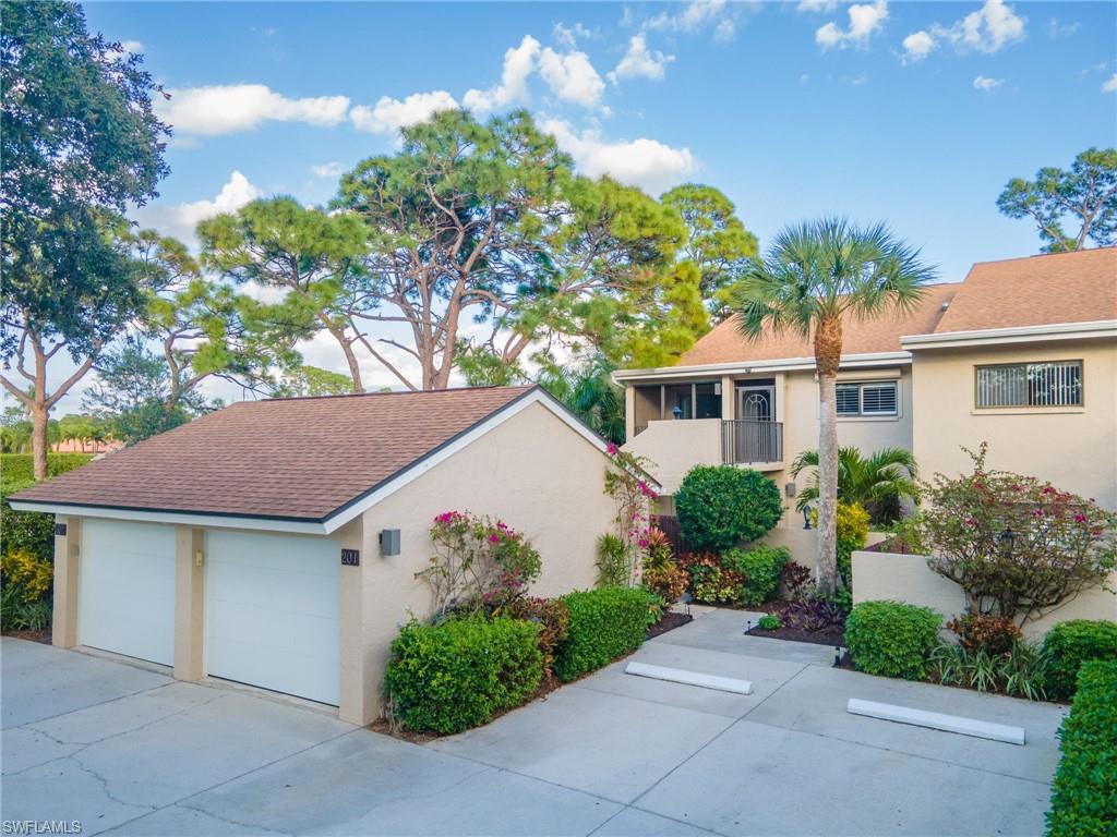 View of front of property featuring one-car garage and parking