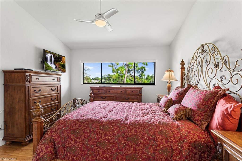Primary bedroom continues vaulted ceiling, and has wood floors and a lake view!
