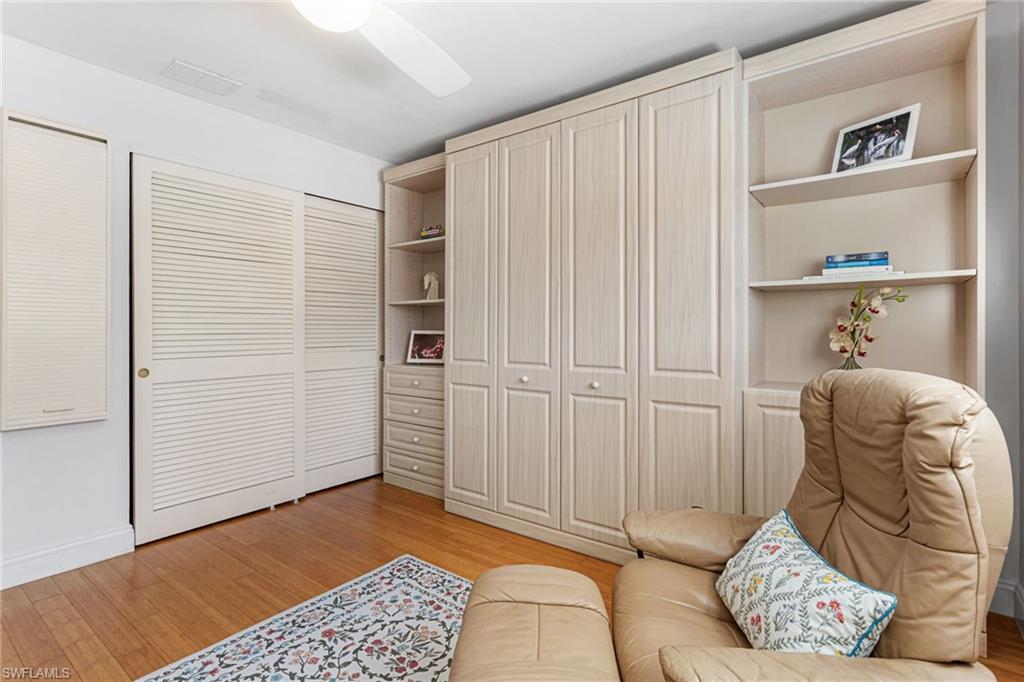 Guest bedroom features wood floors, plantation shutters, and Murphy bed